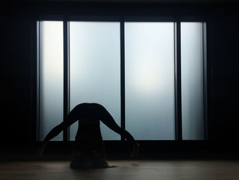 Woman dancing against window