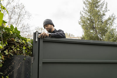 Construction worker installing locks on metal gate