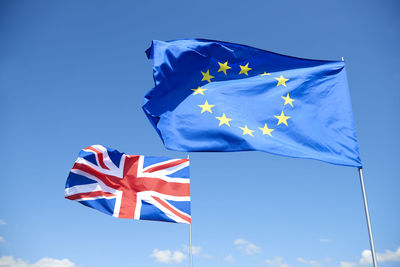 Low angle view of flag against blue sky