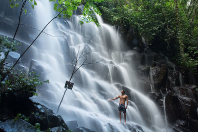 Full length of man on waterfall in trees