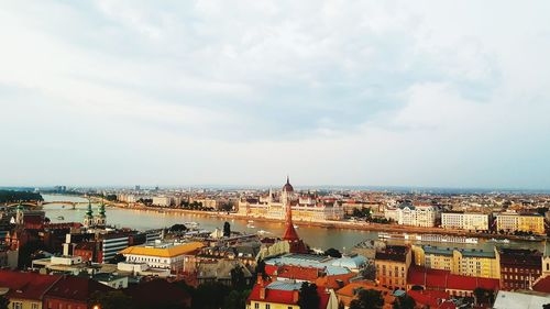 High angle view of city buildings against cloudy sky