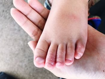 Close-up of parent holding baby leg