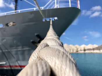 Close-up of sailboats moored on sea against sky