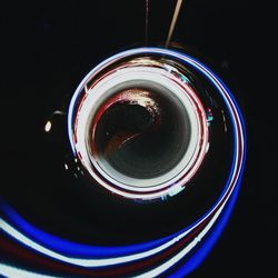 Close-up of illuminated light bulb against black background