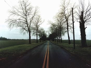 Road amidst trees against clear sky