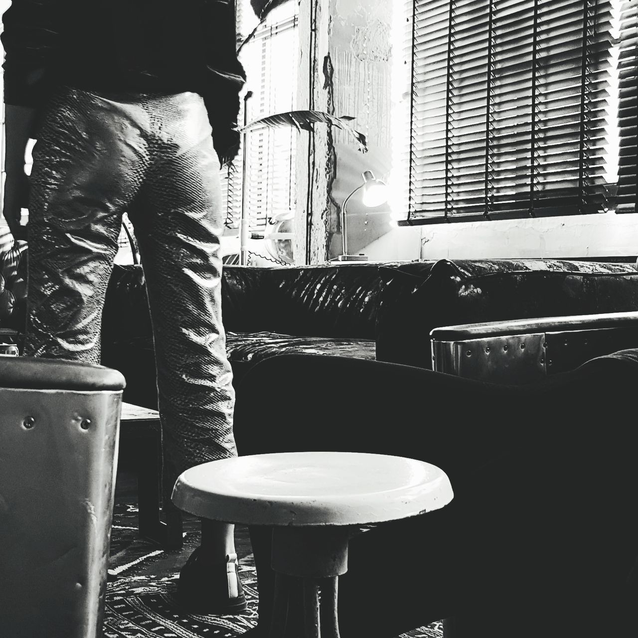 CLOSE-UP LOW SECTION OF MAN STANDING ON CHAIR