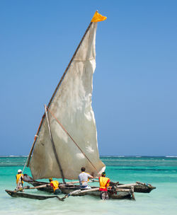 People pushing boat in sea