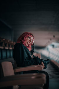 Side view of young woman sitting on seat
