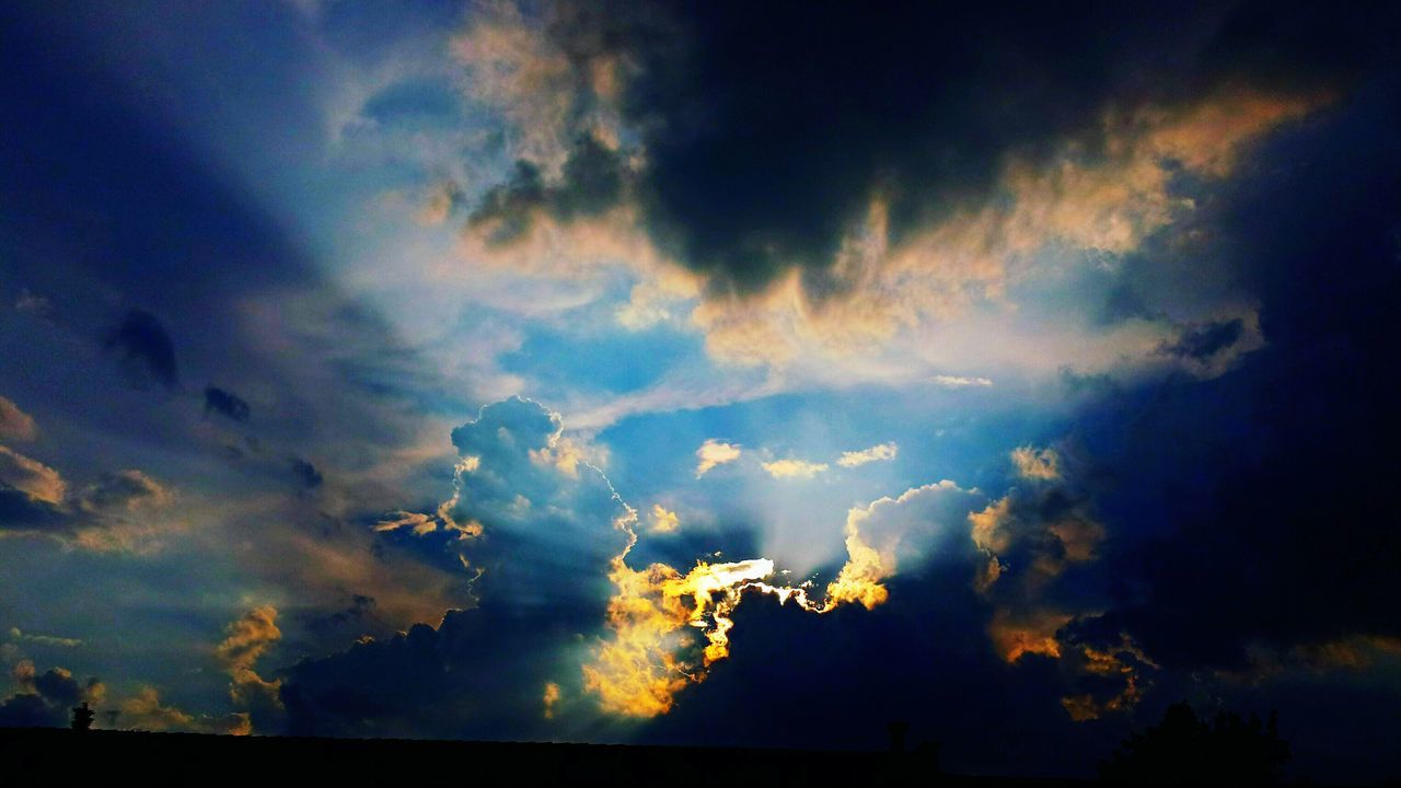 low angle view, sky, cloud - sky, beauty in nature, sunset, tranquility, dramatic sky, scenics, nature, cloudscape, majestic, sunbeam, sky only, atmosphere, storm cloud, tranquil scene, cloud, cloudy, blue, back lit, atmospheric mood, outdoors, day, no people, vibrant color