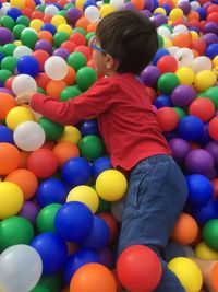 High angle view of boy playing in ball pool