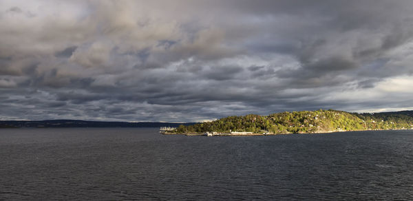 Scenic view of sea against storm clouds