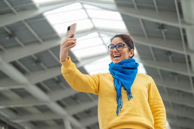 Portrait of smiling young woman using mobile phone