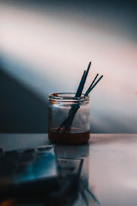 Close-up of paint brushes in container on table