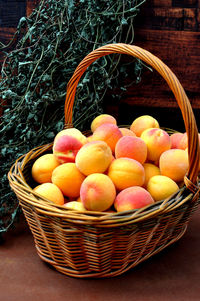 Basket with apricots and dried mint leaves bunch