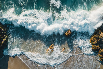 Aerial image of waves hitting the coastline of the french island corse near the village lumio.