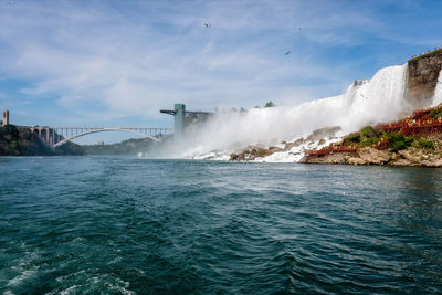 Rainbow bridge over river and american side of niagara falls