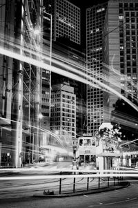 Light trails on street against buildings in city at night