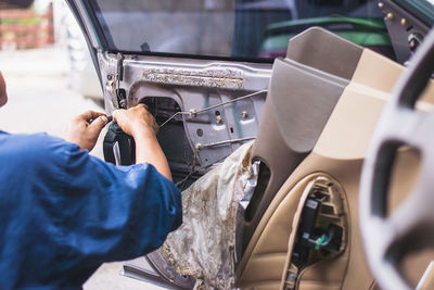 Midsection of man holding car