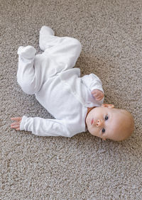 High angle portrait of cute boy lying on floor