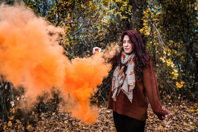 Young woman standing in forest during autumn