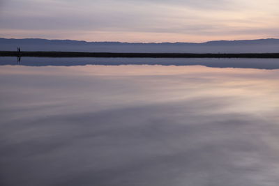 Scenic view of calm lake against cloudy sky