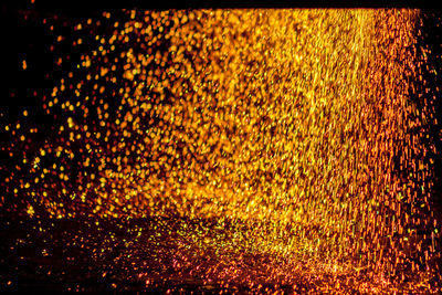 Defocused image of illuminated lights against black background