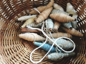 High angle view of spools in wicker basket