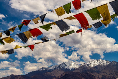 Low angle view of flags on mountain against sky