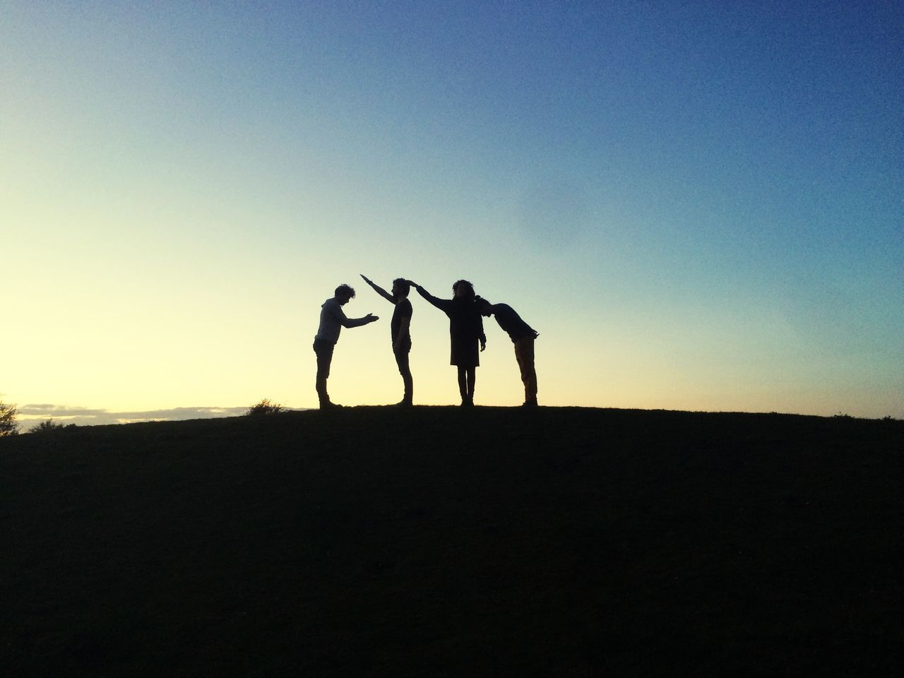 silhouette, togetherness, leisure activity, men, lifestyles, copy space, clear sky, friendship, bonding, sunset, full length, person, standing, love, nature, landscape, outline