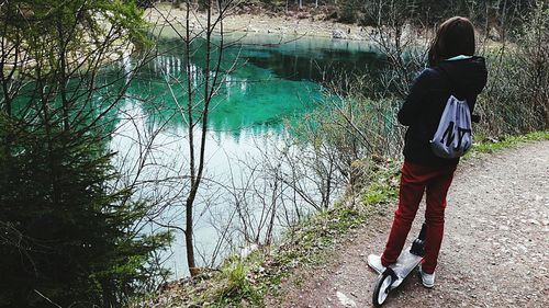 Rear view of woman standing on riverbank