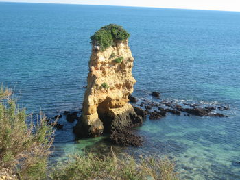 High angle view of rock formation in sea against sky