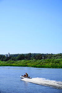 Couple enjoying inflatable motorboat ride in river