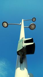 Low angle view of lighting equipment against clear blue sky