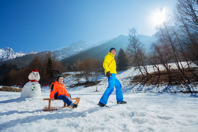 Rear view of woman skiing on snow covered landscape