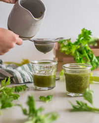 Cropped image of person pouring drink in glass