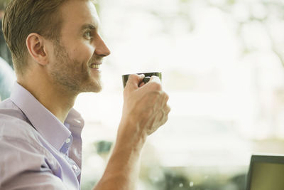 Side view of man having coffee