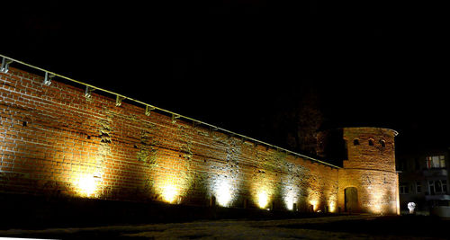 Low angle view of illuminated building against sky at night