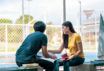 Rear view of couple sitting in park