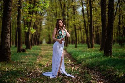 Full length of woman standing in forest