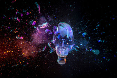 Bulb destroying on black background with coloured lights