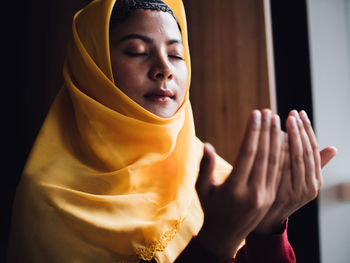 Low angle view of young woman praying