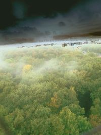View of calm beach against cloudy sky