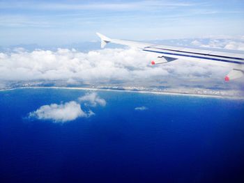 Cropped image of airplane flying over clouds