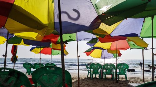 Multi colored umbrellas on beach against sky