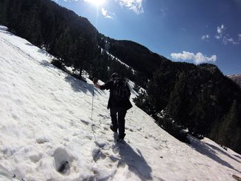 Full length of man standing on mountain against sky during winter