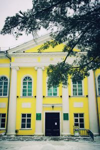 Yellow built structure against trees