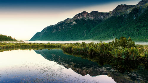 Scenic view of lake and mountains against sky