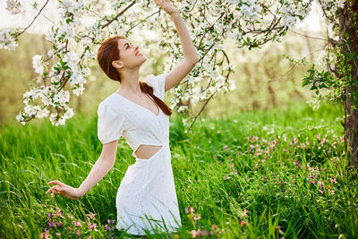 Young woman standing on grassy field