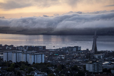 High angle view of buildings by sea against sky