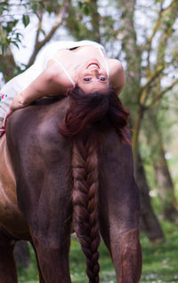 Portrait of young woman against trees